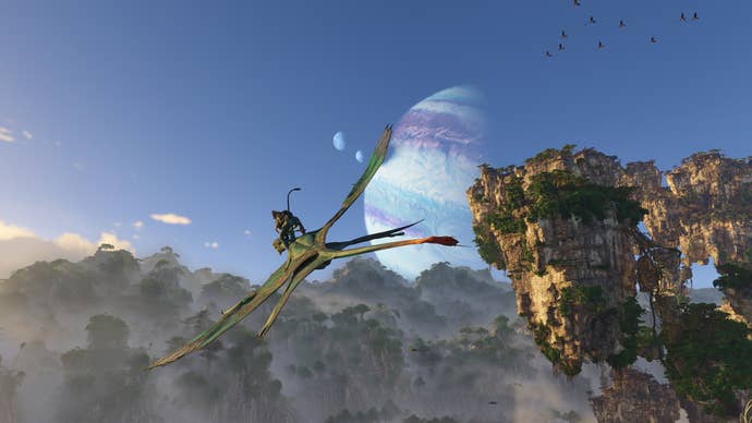Un Na'vi chevauche un ikran – une créature aviaire ressemblant à un reptile – dans le ciel bleu d'Avatar : Frontiers of Pandora, avec une paire de planètes visibles dans le ciel au-dessus.