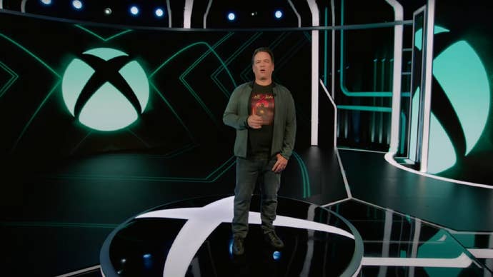 Phil Spencer devant un logo Xbox.