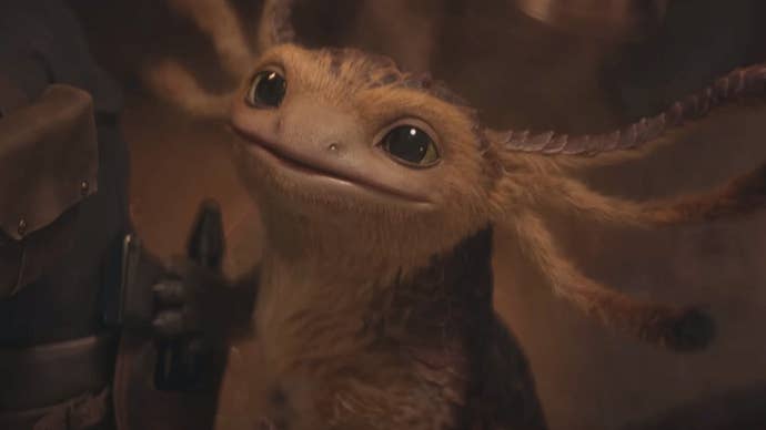 Vix, un petit extraterrestre ressemblant à un axolotl dans Star Wars Outlaws, lève les yeux vers la caméra avec curiosité.